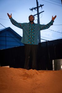Actor talking on red dirt mound