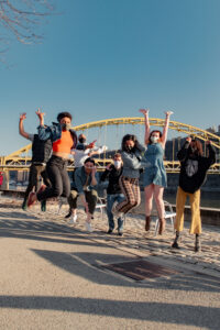 group jumping in front of bridge