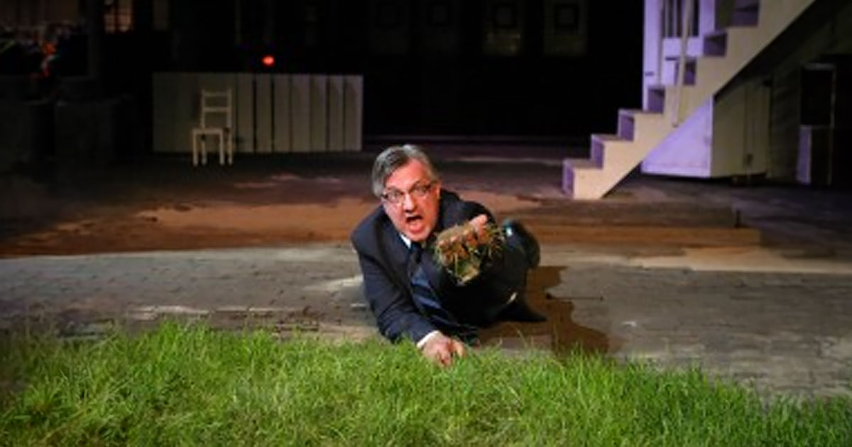 Actor on ground holding grass